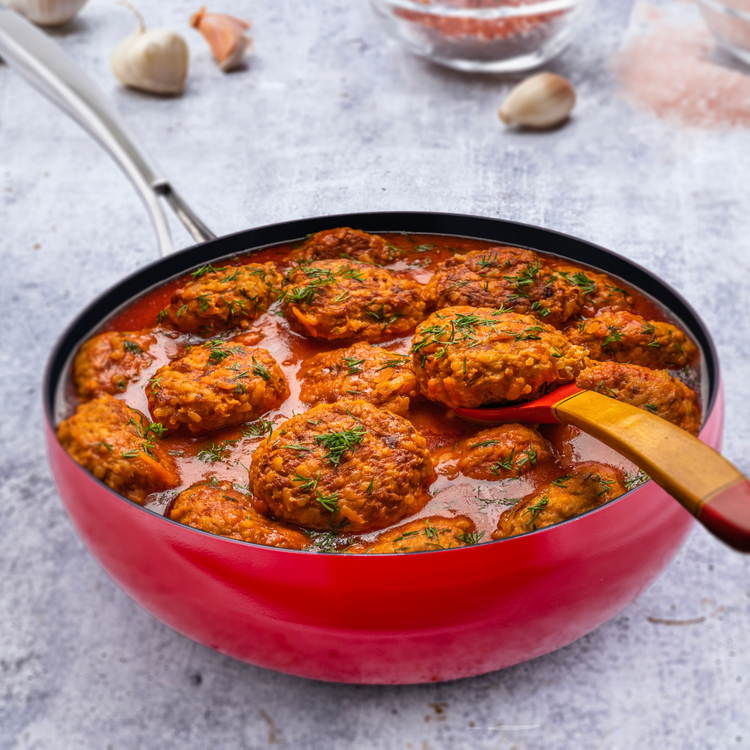 meatballs in gravy in a red wok